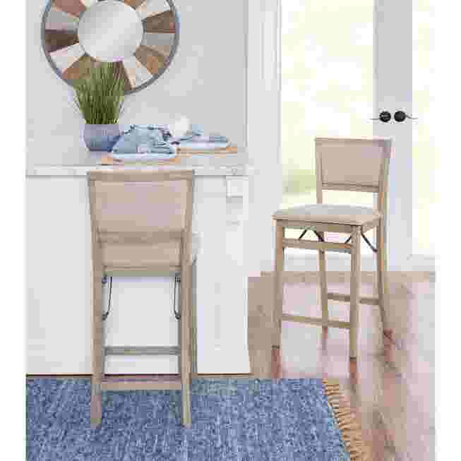 Two grey wash folding counter stools in a kitchen setting
