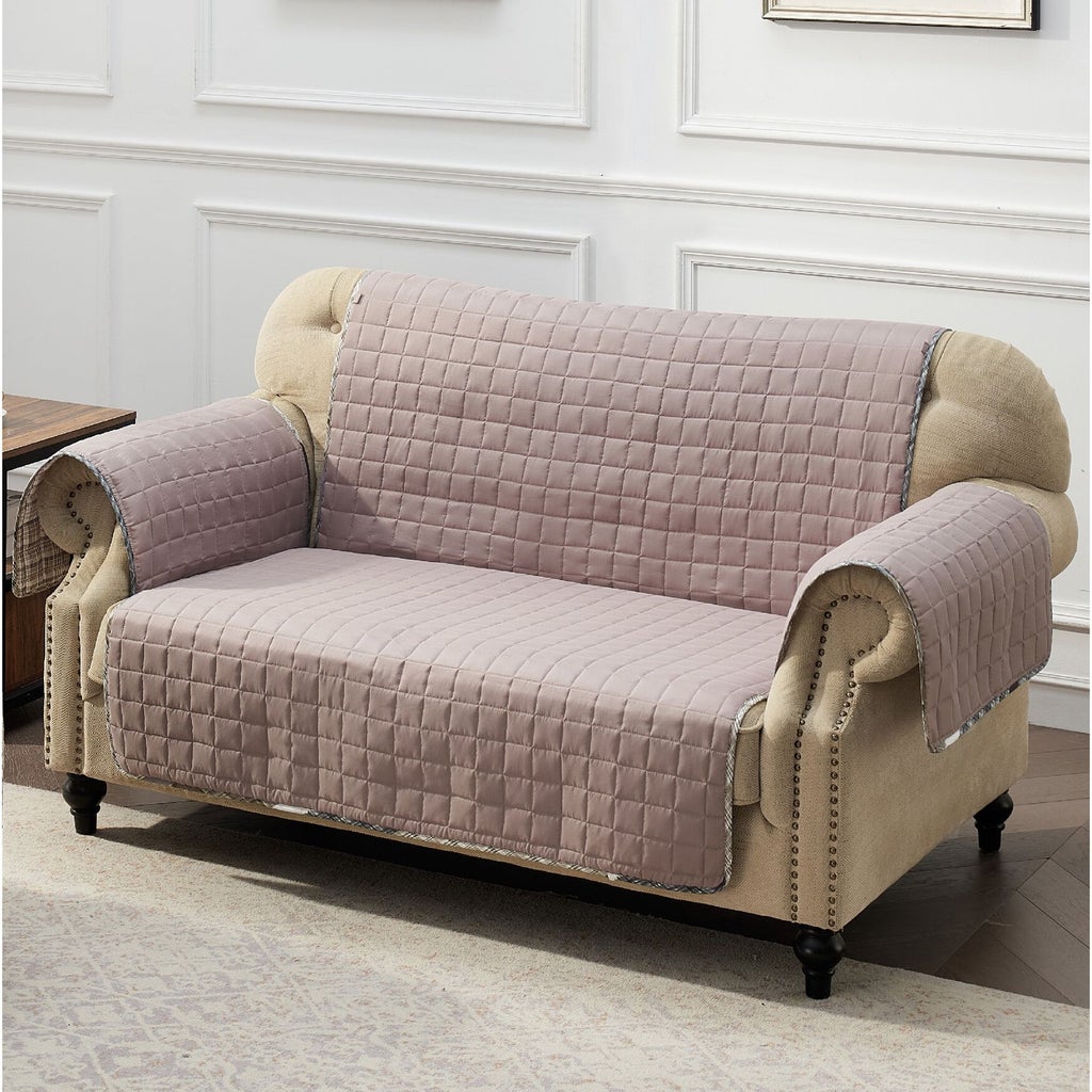 Light pink quilted furniture protector on beige sofa