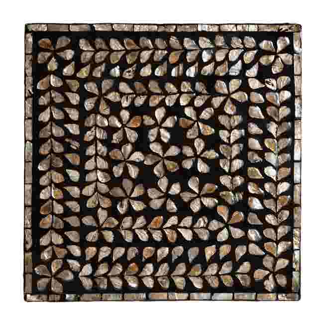 A top-down view of a modern bohemian end table with a black and bronze mother of pearl inlay, showcasing a leaf pattern.