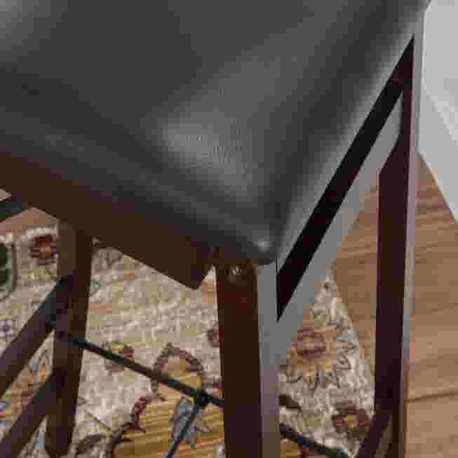 Close-up of the seat and frame of a black folding bar stool