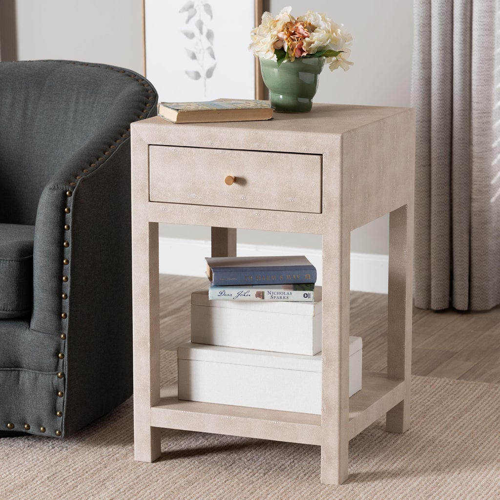 Beige faux shagreen 1-drawer end table with flowers on top beside a sofa