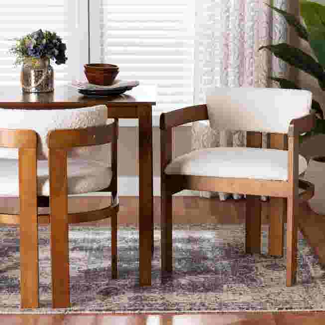 Cream boucle dining chair with wooden frame in a dining setting