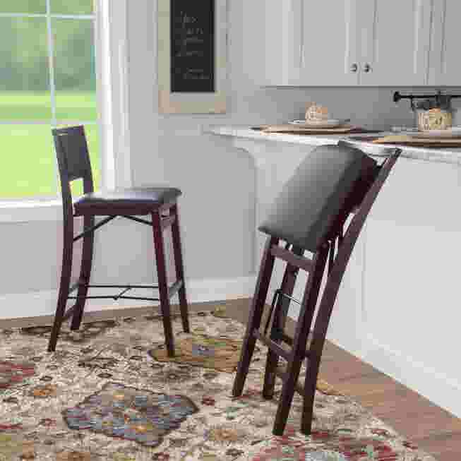 Two black folding bar stools in a kitchen setting