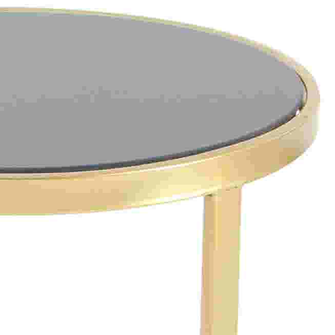 Close-up of the gold metal frame and black top of an accent table.