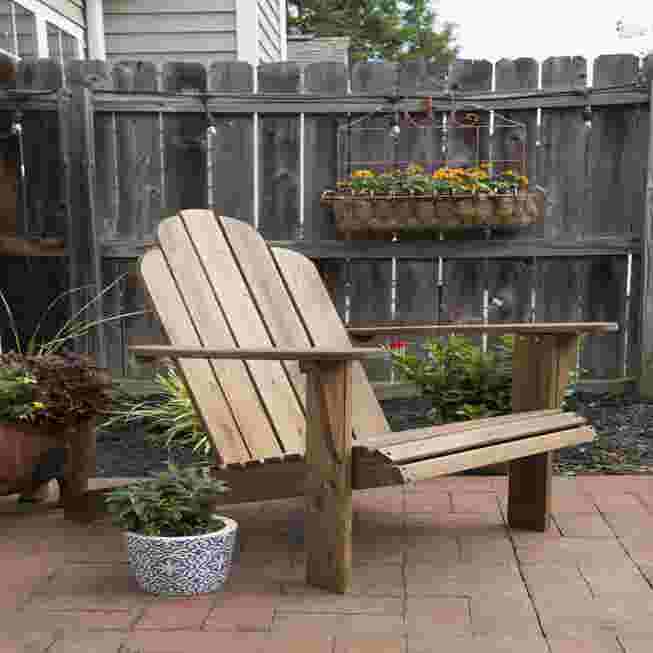 Wooden Adirondack chair on a patio.