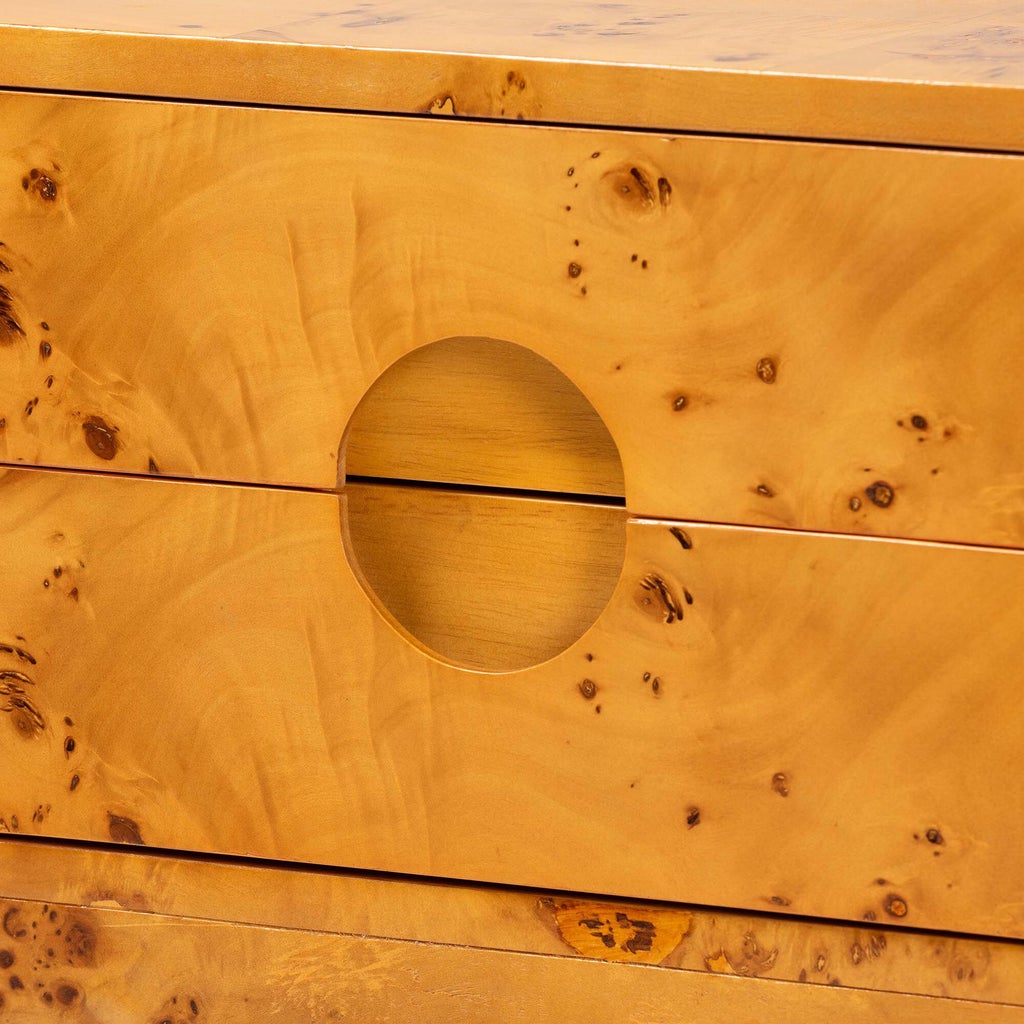 Close-up of circular pull and burl wood drawer front on nightstand.