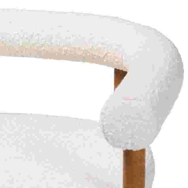 Close-up of the armrest of a white boucle dining chair