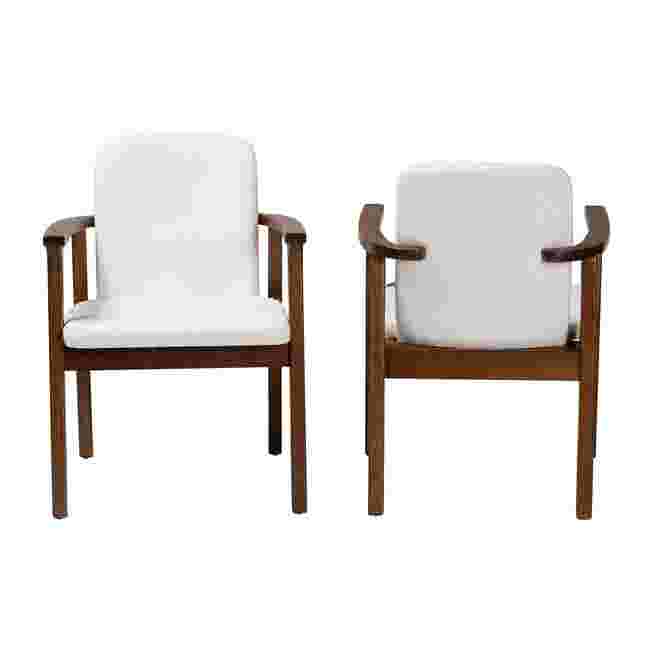 Two white upholstered armchairs with dark wood frames
