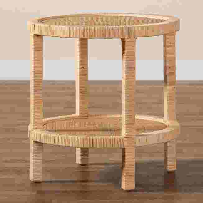 A round, two-tier end table made of natural rattan and wood, shown on a wooden floor.