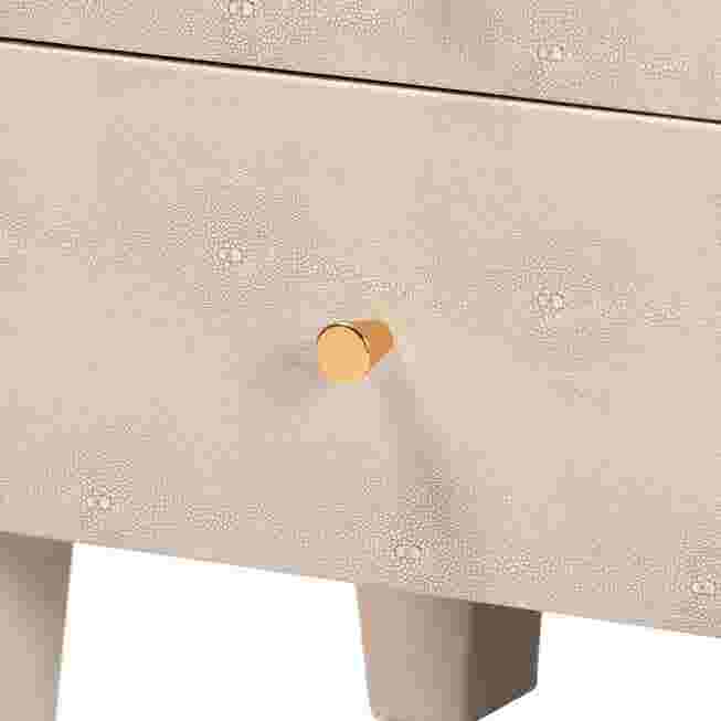 Close-up of a drawer knob on a beige faux shagreen end table.