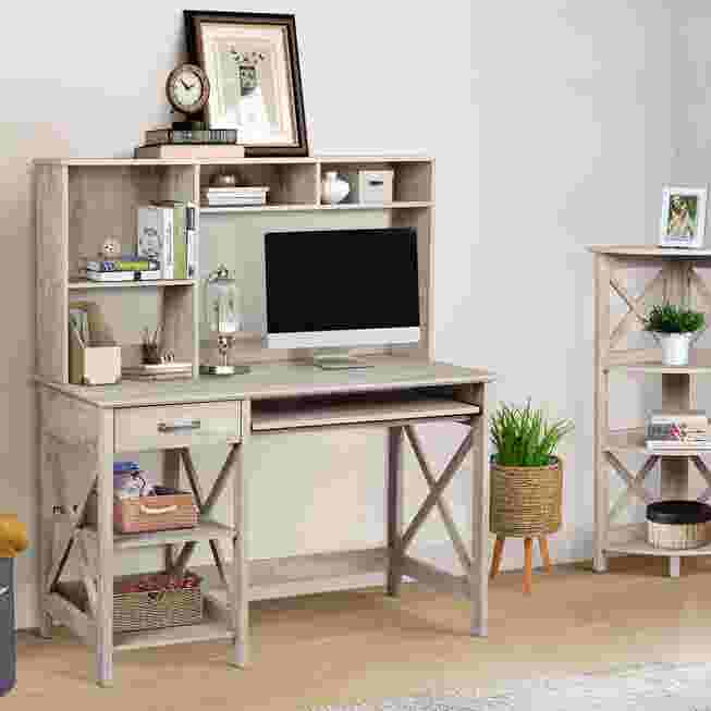 A light gray writing desk with a hutch, computer monitor, and decorative items in a room setting.