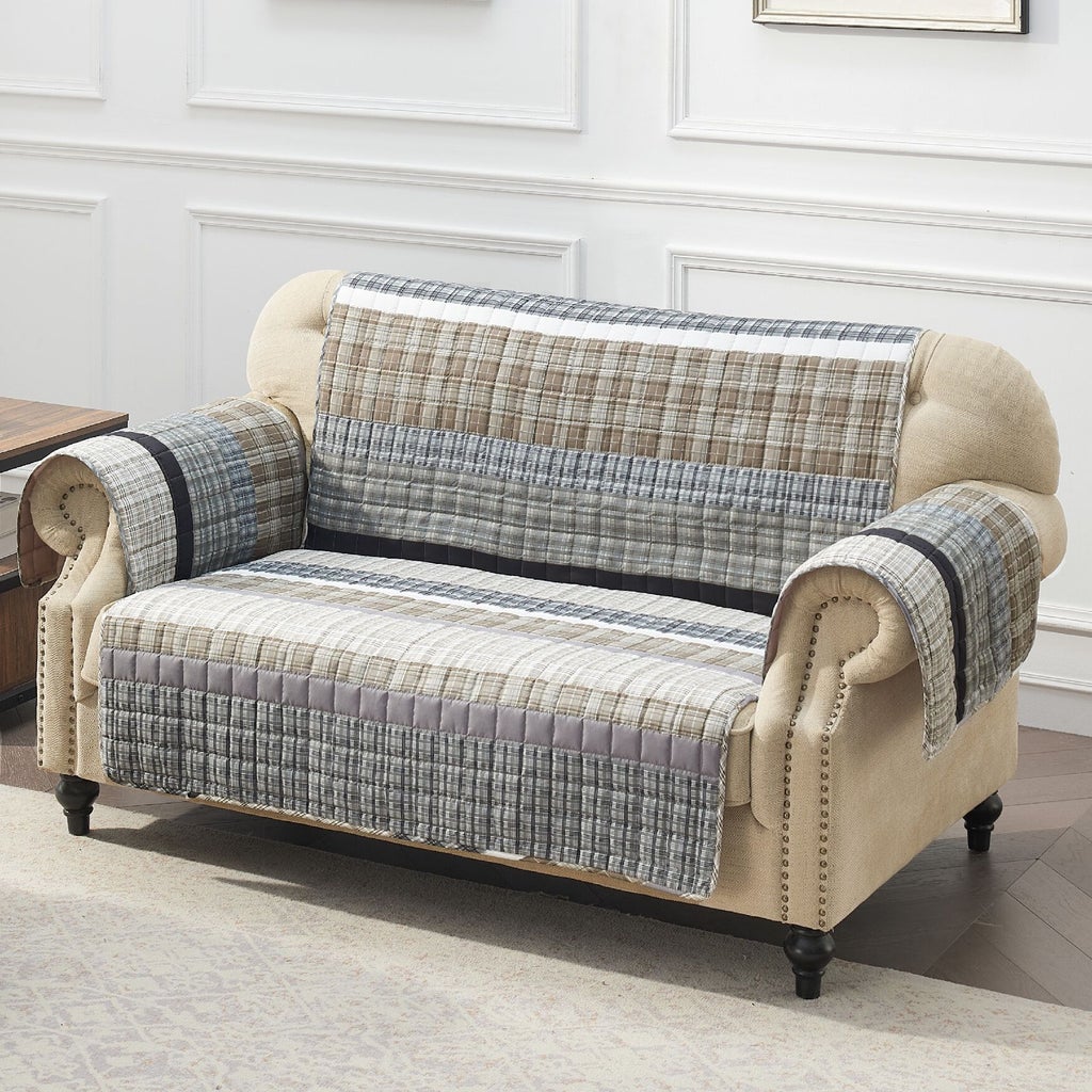 Beige sofa with gray plaid quilted furniture protector