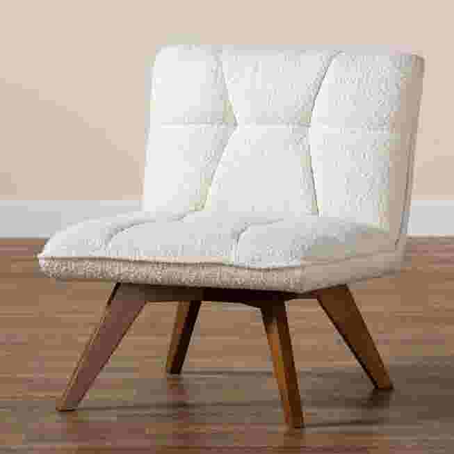 Cream boucle fabric accent chair with wooden legs on a wooden floor