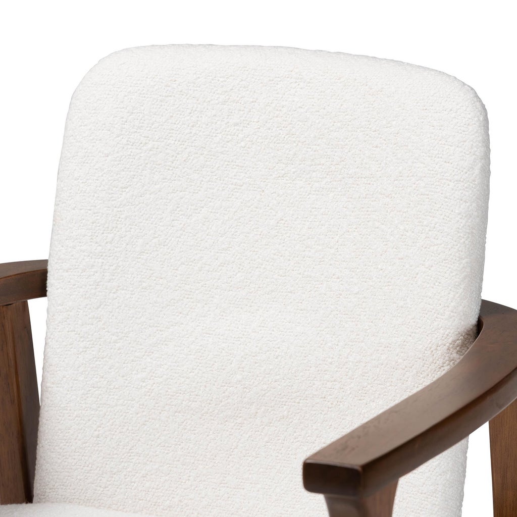 Close-up of white textured chair upholstery and wooden armrest