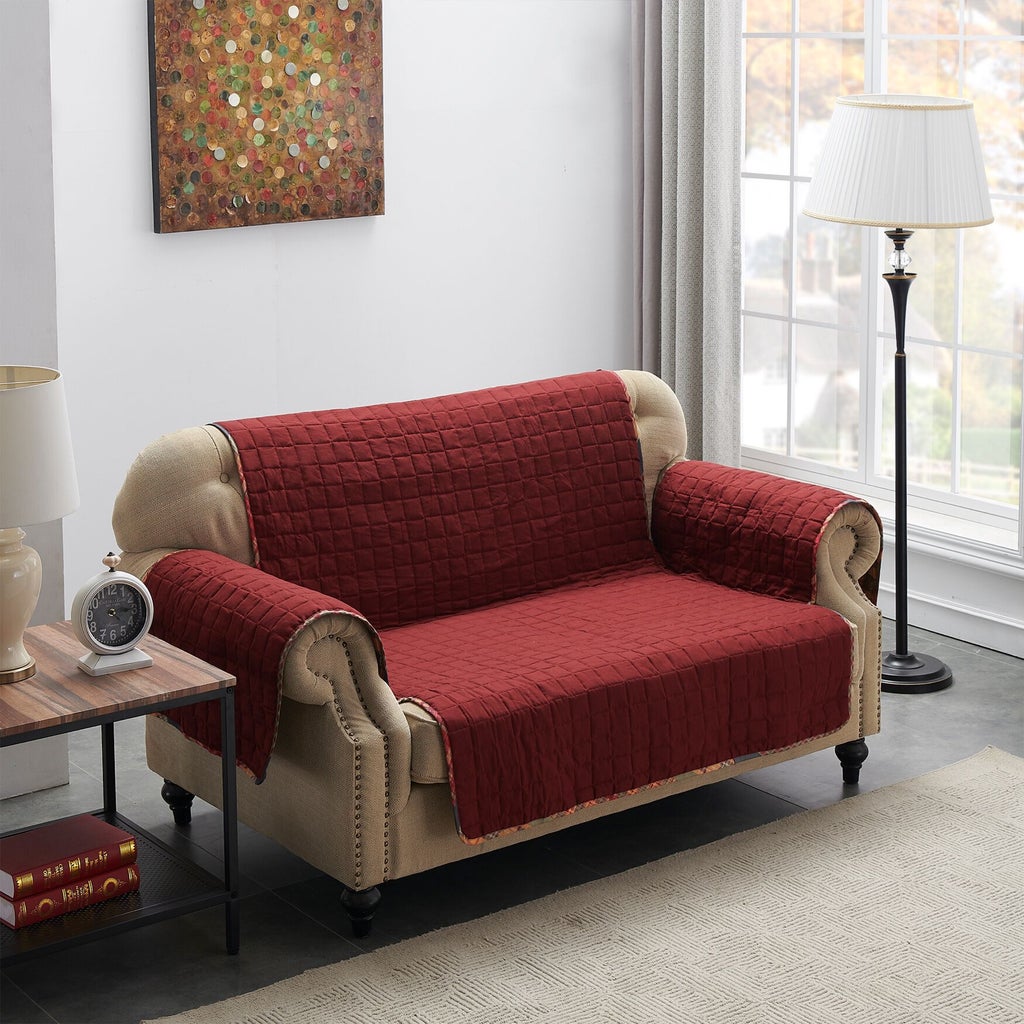 Beige sofa with red quilted furniture protector