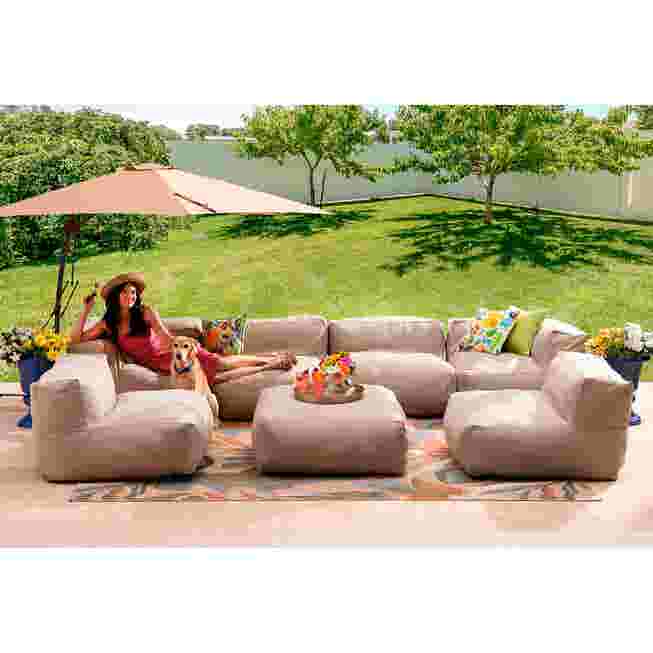 Beige modular seating on a patio with a woman relaxing in the chair.