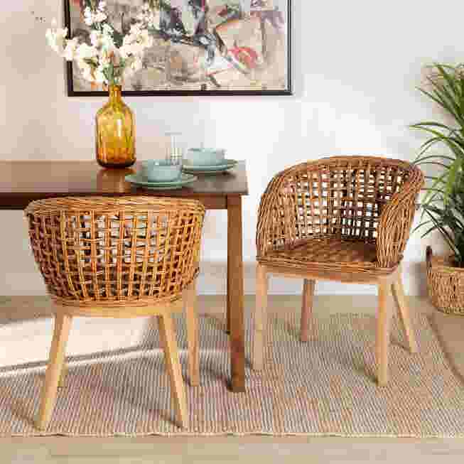 Two wicker dining chairs in a dining room setting