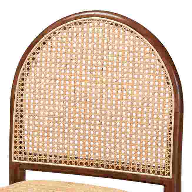 Close-up of the arched rattan back of a dining chair.