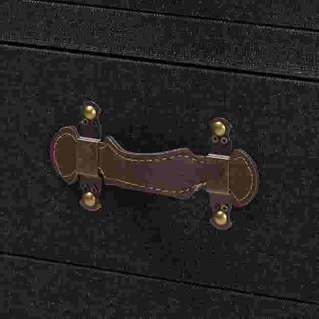 close-up of a brown leather drawer pull with brass hardware