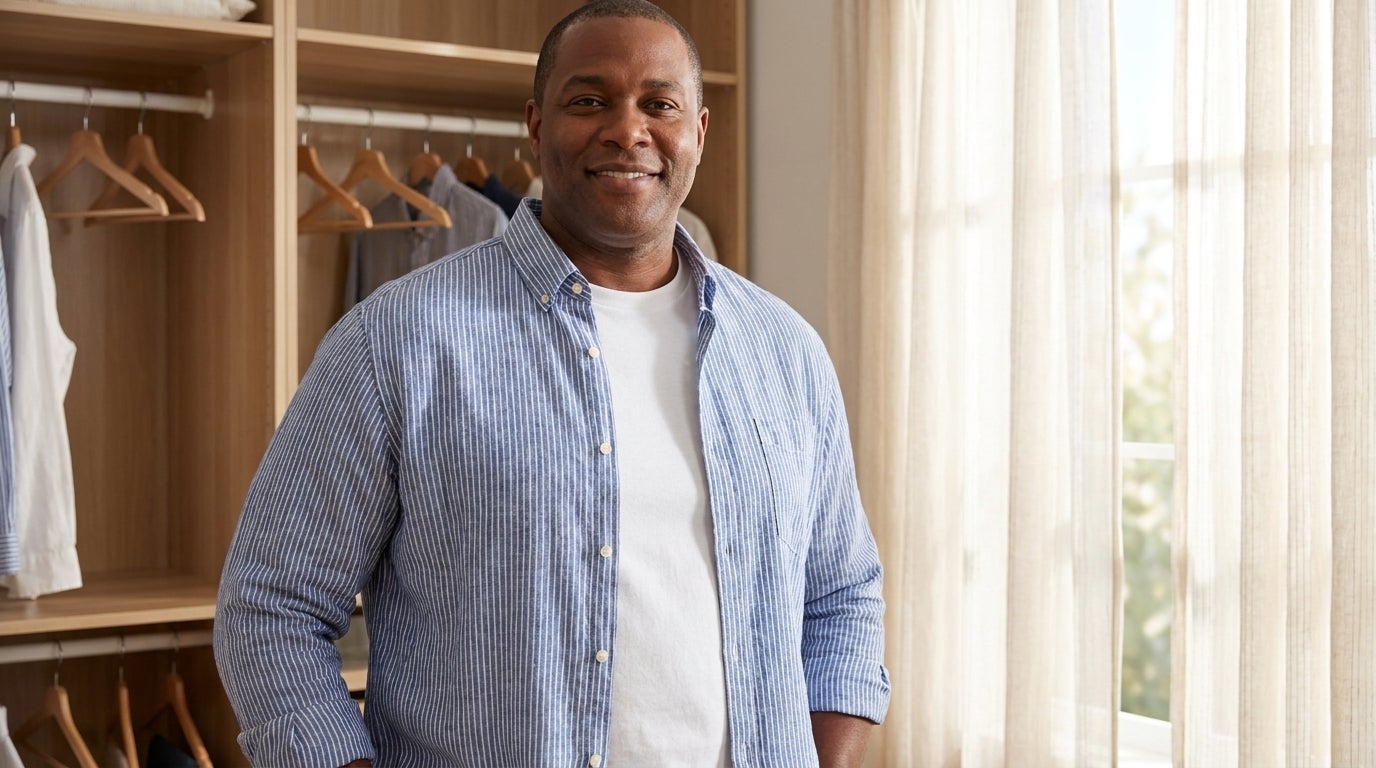 Man wearing a cotton crewneck undershirt layered under an open button-down shirt